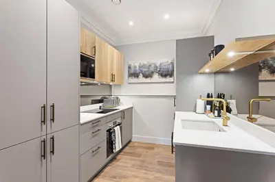 a kitchen with white cabinets and a sink at Prime Central Edinburgh 1 bed in Edinburgh