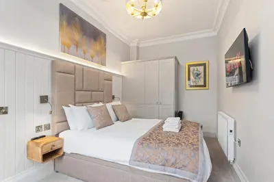 a bedroom with a large white bed and a chandelier at Prime Central Edinburgh 1 bed in Edinburgh