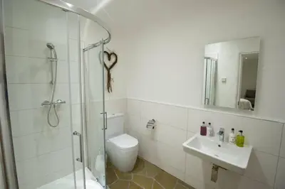 a bathroom with a shower and a toilet and a sink at The Warren - Hobbit House and Hot Tub at Loch Tay in Lawers