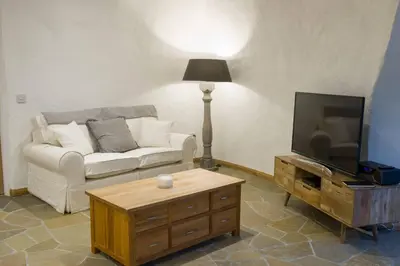 a living room with a couch and a tv at The Warren - Hobbit House and Hot Tub at Loch Tay in Lawers