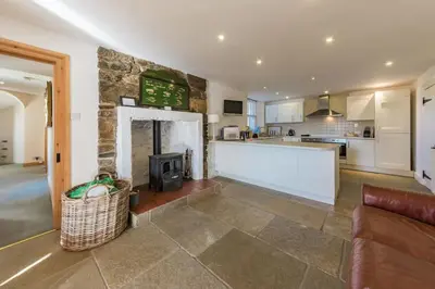 a kitchen and a living room with a fireplace at Loch Tay, Estate House with Panoramic Vistas in Lawers