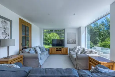 a living room with couches and a flat screen tv at Loch Tay, Estate House with Panoramic Vistas in Lawers