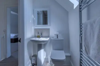 a white bathroom with a toilet and a sink at Loch Tay, Estate House with Panoramic Vistas in Lawers