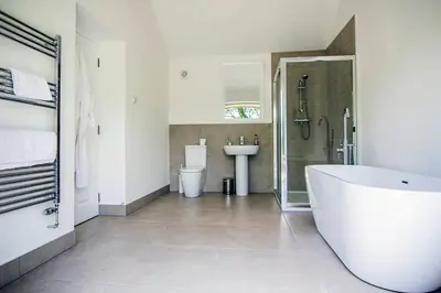 a white bathroom with a tub and a sink at Wishing Well Cottage at Loch Tay and Hot Tub in Lawers