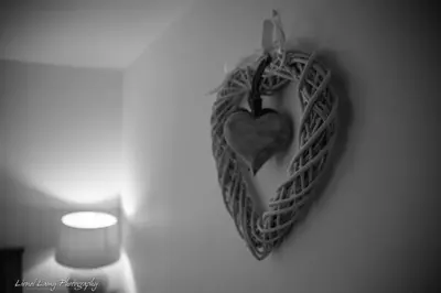 a heart hanging on a wall next to a candle at Sams Cottage with Loch Tay Vistas and Hot Tub in Lawers