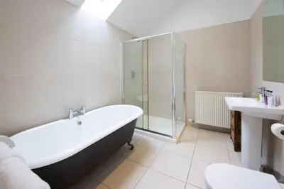a bathroom with a tub and a shower and a toilet at Loch Tay Bothy Cottage with Hot Tub in Lawers