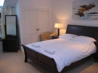 a bedroom with a large bed with two towels on it at Loch Tay Bothy Cottage with Hot Tub in Lawers