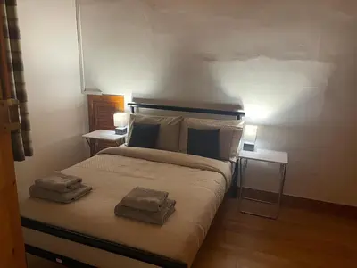 a bedroom with a bed with two towels on it at Quirky Cottage Central Bathgate in Bathgate