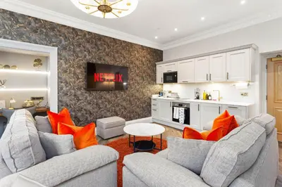 a living room with two gray couches and orange pillows at Prime Central Edinburgh 2 bed in Edinburgh