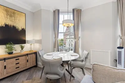 a dining room with a table and chairs and a window at Prime Central Edinburgh 2 bed in Edinburgh