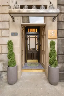 two bushes in pots in front of a door at Prime Central Edinburgh 2 bed in Edinburgh