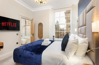 a bedroom with a large bed with a blue blanket at Prime Central Edinburgh 3 bed in Edinburgh