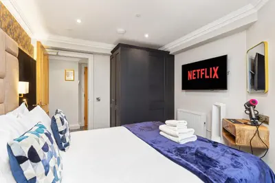 a bedroom with a bed and a tv on the wall at Central Edinburgh Prime Luxury in Edinburgh