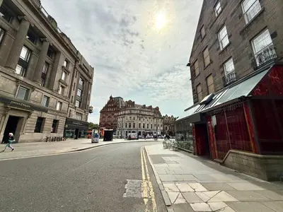 an empty street in a city with tall buildings at Central Edinburgh Prime Luxury 3 bed in Edinburgh