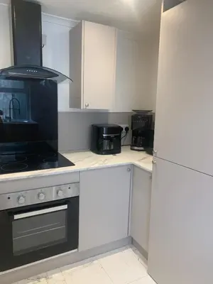 a kitchen with white cabinets and a stove top oven at Highland Hideaway Helensburgh in Helensburgh
