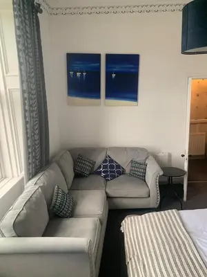 a living room with a couch with pillows on it at Highland Hideaway Helensburgh in Helensburgh