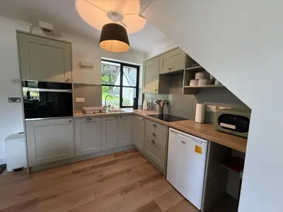 a kitchen with gray cabinets and wooden floors at Highland Nook in Fort William