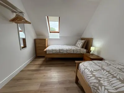 a attic bedroom with two beds and a window at Highland Nook in Fort William
