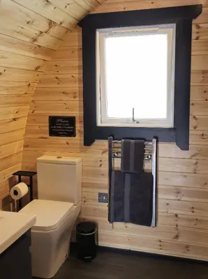 a bathroom with a toilet and a window at Loch Leven Pods in Kinlochleven