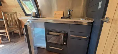 a small kitchen with a stove and a sink at Loch Leven Pods in Kinlochleven