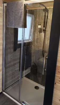 a shower with a glass door in a bathroom at Loch Leven Pods in Kinlochleven