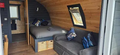 a couch and a bed in a tiny house at Loch Leven Pods in Kinlochleven