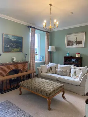 a living room with a couch and a fireplace at Fordie South Cottage in Comrie