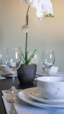 a table with wine glasses and a flower in a vase at Mercer Apartment in Alloa