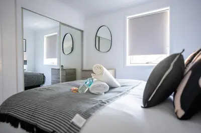 a bedroom with a bed with pillows and a mirror at Mercer Apartment in Alloa