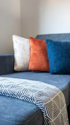a couch with three pillows on top of it at Mercer Apartment in Alloa