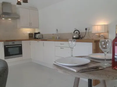 a kitchen with two wine glasses on a table at The Dairy Cottage, Loch Tay, Hot Tub and Garden in Lawers