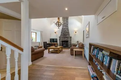 a living room with a fireplace and a couch at The Barn on Loch Tay - Hot Tub in Lawers