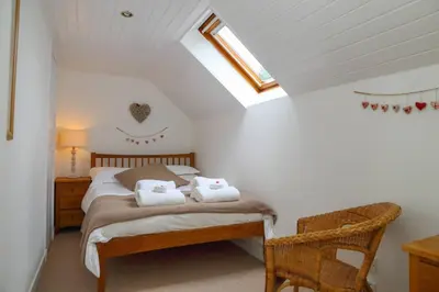 a bedroom with a bed with towels on it at The Barn on Loch Tay - Hot Tub in Lawers