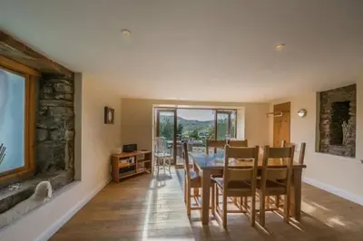 a kitchen and dining room with a table and chairs at The Barn on Loch Tay - Hot Tub in Lawers