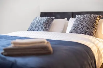 a bed with two towels on top of it at Stylish Stay in Inverkeithing. in Fife