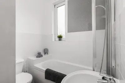 a bathroom with a tub and a toilet and a sink at Stylish Stay in Inverkeithing. in Fife