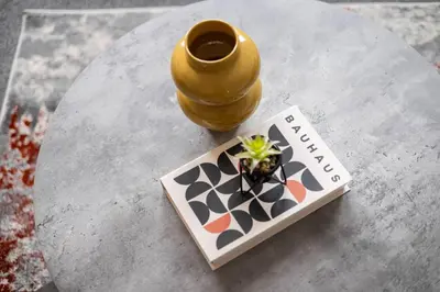 a table with a vase and a book on it at Stylish Stay in Inverkeithing. in Fife