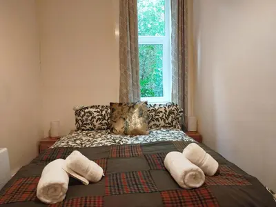 a bedroom with a bed with pillows and a window at Lovely flat in Gorgie, Edinburgh in Edinburgh
