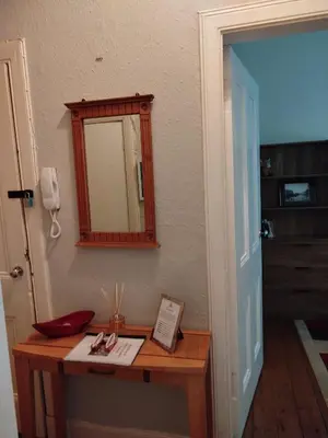 a mirror on a wall next to a table at Lovely flat in Gorgie, Edinburgh in Edinburgh