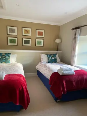 a bedroom with two beds and a window at Fordie West Cottage in Comrie