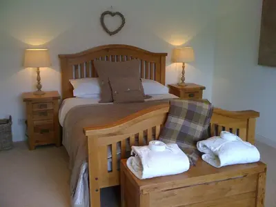 a bedroom with a bed with two towels on it at Oak Cottage and Hot Tub, Loch Tay in Lawers