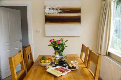 a dining room table with food and flowers on it at Oak Cottage and Hot Tub, Loch Tay in Lawers