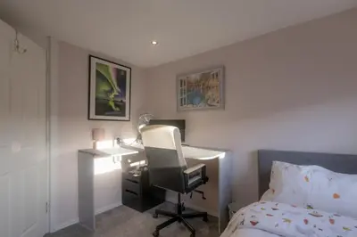 a bedroom with a desk and a bed at 2-Bedroom Home Away From Home in Glasgows' East End with FREE Parking in Mount Vernon