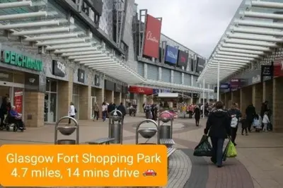 a group of people walking through a shopping mall at 2-Bedroom Home Away From Home in Glasgows' East End with FREE Parking in Mount Vernon