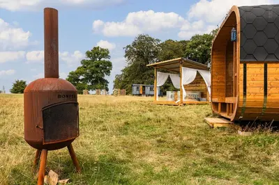 a wooden stove in a field next to a cabin at Redwood in Moffat