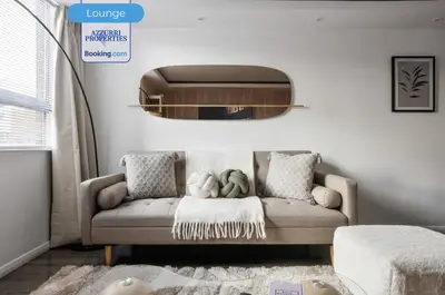 a living room with a couch and a mirror at Cozy 4-Bedrooms House By Azzurri Properties Short Lets & Serviced Accommodation London With Private Garden, Wi-Fi in Moffat
