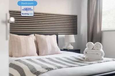 a bedroom with a bed with towels on it at Cozy 4-Bedrooms House By Azzurri Properties Short Lets & Serviced Accommodation London With Private Garden, Wi-Fi in Moffat