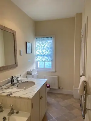 a bathroom with a sink and a mirror at Fordie East Cottage in Comrie