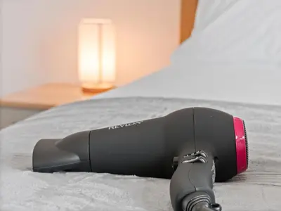 a remote control sitting on top of a bed at Whiteside 3 Bedroom Apartment - Bathgate in Bathgate