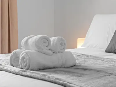 a pile of towels sitting on top of a bed at Whiteside 3 Bedroom Apartment - Bathgate in Bathgate